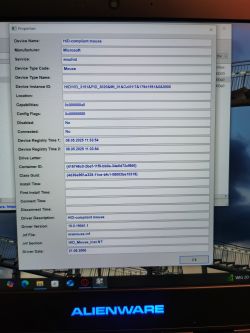Okno właściwości urządzenia HID-compliant mouse na tle pulpitu laptopa Alienware.