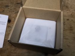 SWP86-01OG Socket in Packaging SWP86-01OG electrical socket in white protective foil inside an open cardboard box.