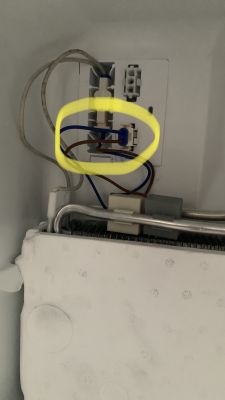 Zbliżenie na złącze elektryczne z kablami w urządzeniu, z zaznaczeniem żółtym kolorem.