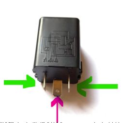 Przekaźnik samochodowy z trzema pinami i schematem elektrycznym na obudowie.