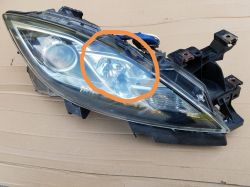 Zdjęcie reflektora samochodowego z pomarańczowym obrysem na jednym z obszarów.