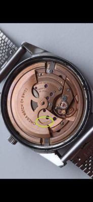 Mechanizm zegarka Omega z widocznym rotorem i napisem SWISS.