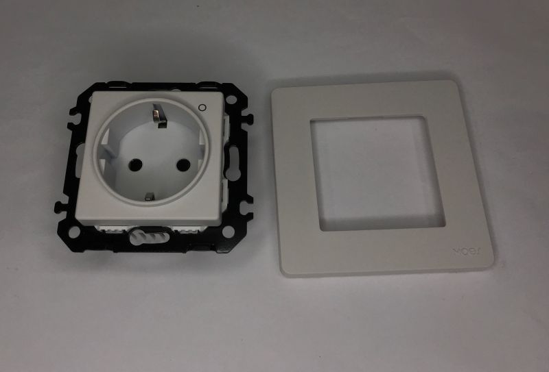 Schuko in-wall socket with black mounting frame and a removed white faceplate placed beside it