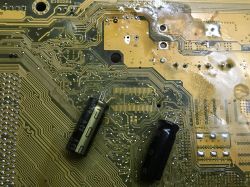 Motherboard with visible traces and desoldered capacitors