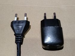 Prosta ładowarka USB 5V 1A i kabel z końcówką wtyczki Euro na tle tektury