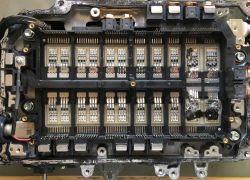 Zbliżenie na uszkodzoną elektronikę z wypalonymi elementami.