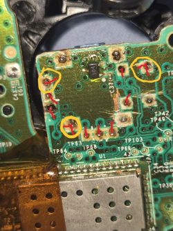 Zbliżenie na płytkę drukowaną z zaznaczonymi żółtymi kółkami i czerwonymi liniami.