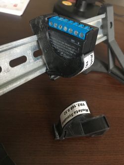 Electrical module mounted on a metal DIN rail.