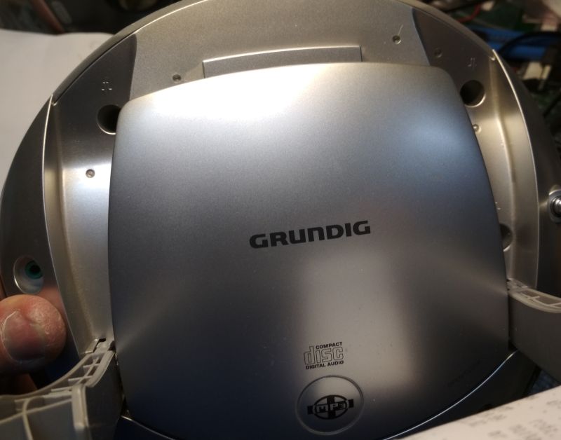Widok zbliżony na górną obudowę srebrnego radioodtwarzacza Grundig z widocznym logotypem i oznaczeniami płyt CD.