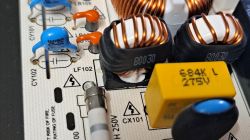 Elementy elektroniczne na płytce drukowanej z widocznymi dławikami.