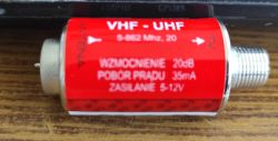 Cylindryczny wzmacniacz antenowy z czerwonym oznaczeniem VHF-UHF, dane techniczne na naklejce.