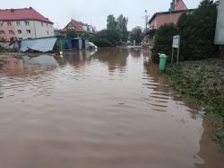 Zalane uliczki z uszkodzonymi budynkami po powodzi