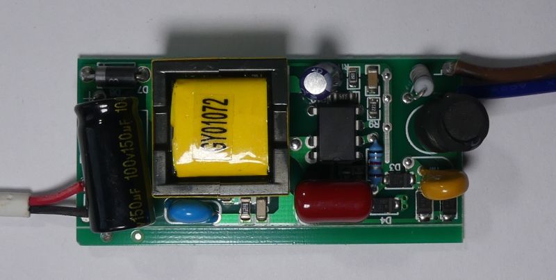 Płytka elektroniki z transformatorem, kondensatorami i przewodami na białym tle