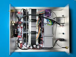 Przedwzmacniacz audio DIY z komponentami elektronicznymi i okablowaniem na niebieskim tle.