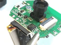 Close-up of a printed circuit board with electronics and a camera module.