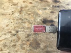 CP2102 USB-to-TTL adapter connected to a USB port of a black device