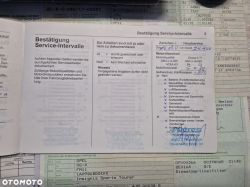 Car service book page with checked service actions and vehicle documents in the background.