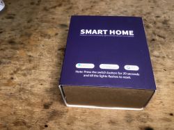 SMART HOME Socket Box Purple SMART HOME product box on a wooden surface, partially open.