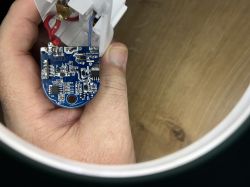 Person hält eine Leiterplatte mit Drähten und elektronischen Bauteilen