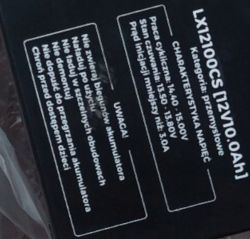 Tabliczka z informacjami na obudowie ładowarki, zawierająca dane techniczne oraz ostrzeżenia dotyczące użytkowania.