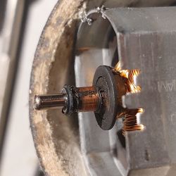 Zbliżenie wnętrza siłownika z widocznym silniczkiem i okablowaniem.