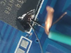 Close-up of soldered wires connected to an integrated circuit on a PCB