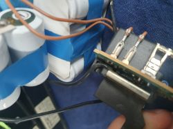 Zbliżenie na ogniwa baterii Ni-MH i płytkę PCB ze złączami i przewodami prowadzącymi od czujników.