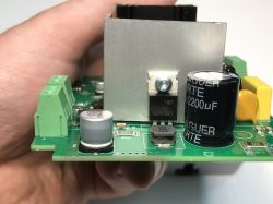 Close-up of a circuit board with visible capacitors, connectors, and a heatsink.
