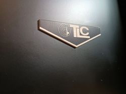 Emblemat TLC na czarnej obudowie