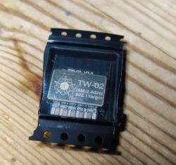 TW-02 Module in Packaging TW-02 module in black packaging on a wooden surface.