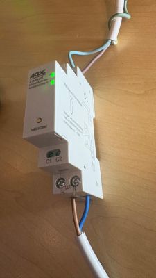 White ACD module with two green LEDs, wired to cables, mounted against a wooden surface.