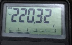 Display of a meter showing a voltage reading of 220.32 V.