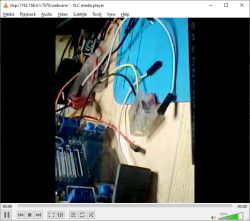 Arduino board with connected wires and relay module on a wooden surface