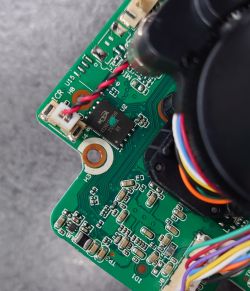 Zbliżenie na płytkę PCB z widoczną kością pamięci flash oraz podpiętymi przewodami.