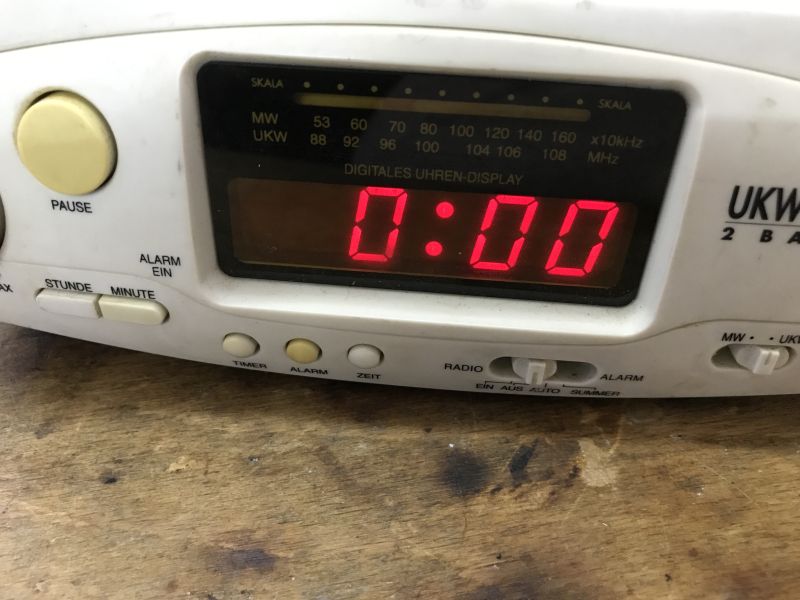 Close-up of a kitchen radio with red 0:00 LED clock display and MW/UKW tuning scale