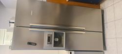 Duża, dwudrzwiowa lodówka Bosch w kolorze inox, z panelem sterowania i dozownikiem wody na lewych drzwiach.