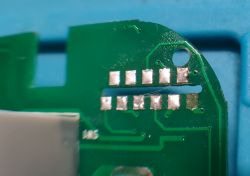 Damaged Solder Pad on Circuit Board Close-up of a circuit board with a damaged solder pad.
