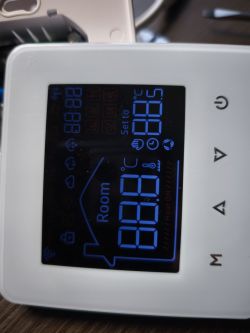 Room thermostat display with blue backlight and various function icons.