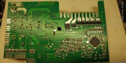 Zielona płytka drukowana z widocznymi ścieżkami i komponentami elektronicznymi, w tym mikrokontroler.