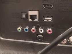 Panel połączeniowy urządzenia z różnorodnymi wejściami, w tym HDMI, LAN, USB i wyjściami audio-wideo.