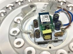 Interior of the Woox ceiling lamp showing the WiFi module and electronic components.