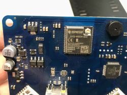 Moduł ESP32-WROOM-32UE na niebieskiej płytce PCB z widocznymi innymi podzespołami elektronicznymi.