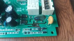Uszkodzony zielony element i przypalony obszar na płytce drukowanej modułu elektronicznego