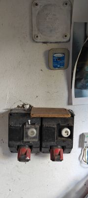 Electrical panel with cartridge fuses in a workshop Electrical distribution board with cartridge fuses and main switches mounted on a white wall.