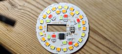 LED printed circuit board with connector and chip on a wooden surface.