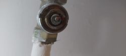 Zbliżenie na metalowy zawór termostatyczny grzejnika bez głowicy