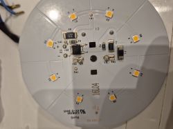 Okrągła płytka elektroniczna z umieszczonymi diodami LED i komponentami lutowanymi.