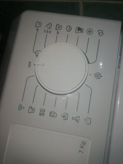 Panel pralki z dużym pokrętłem programów ustawionym na OFF i ikonami programów wokół