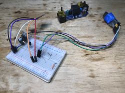 Breadboard with Electronic Components Breadboard with wires and electronic components on a wooden table.