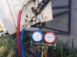 Zestaw manometrów do klimatyzacji podłączony do jednostki zewnętrznej.